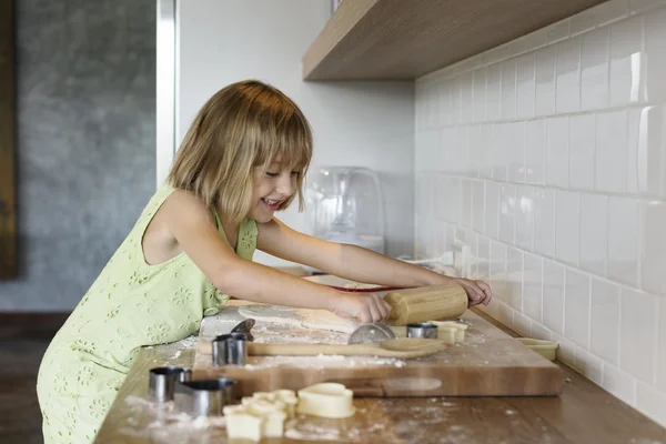 Flicka knåda degen för cookies — Stockfoto