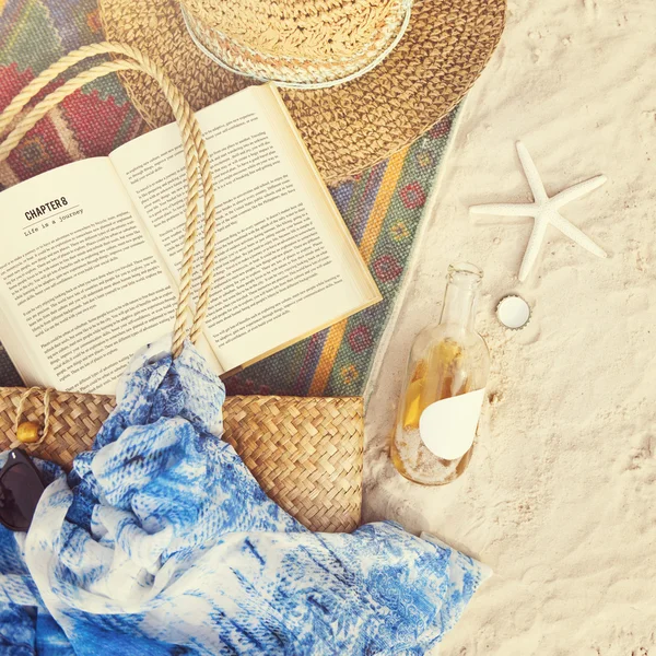 Areia de praia com cobertor e livro — Fotografia de Stock
