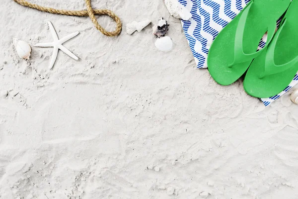 Blanket with flip flops on summer sand — Stock Photo, Image