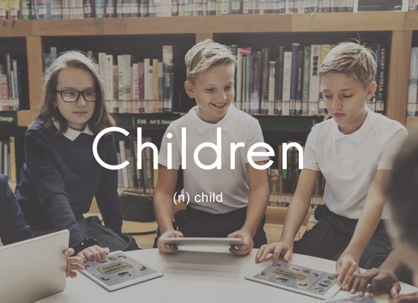 Enfants avec appareils numériques dans la bibliothèque — Photo