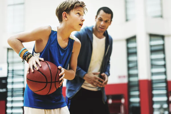 Esportista ensinando menino jogar basquete — Fotografia de Stock