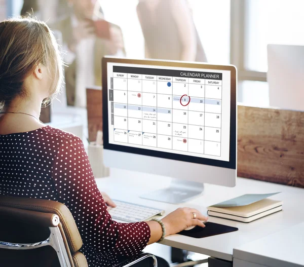 Empresária trabalhando no computador com calendário — Fotografia de Stock