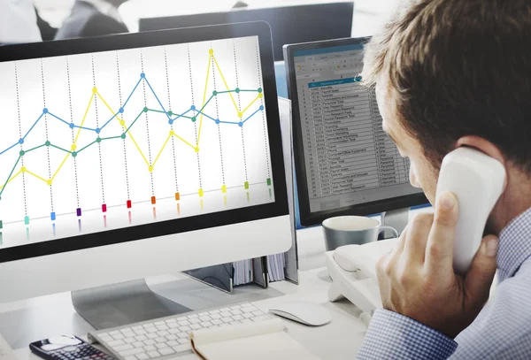グラフを使用してコンピューターに取り組んでの実業家 — ストック写真