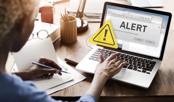 Woman working on laptop with alert — Stock Photo, Image
