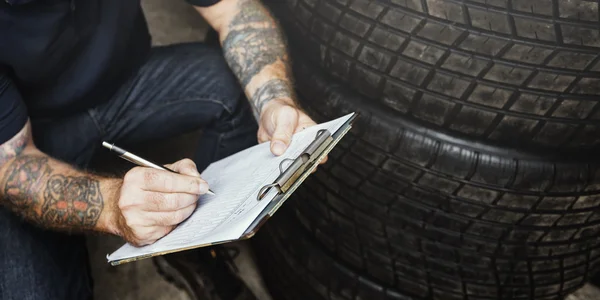 Carro mecânico escrevendo notas na garagem — Fotografia de Stock