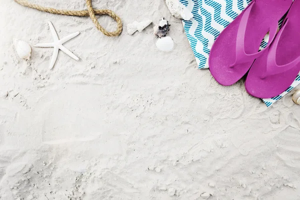 Blanket with flip flops on summer sand — Stock Photo, Image
