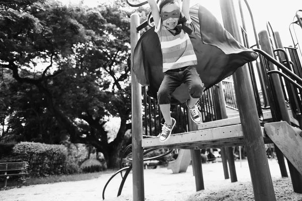 Маленький мальчик-супергерой на детской площадке — стоковое фото