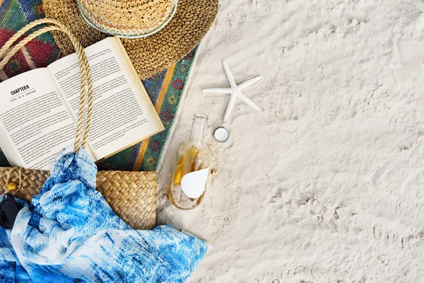 Beach sand with blanket and book — Stock Photo, Image