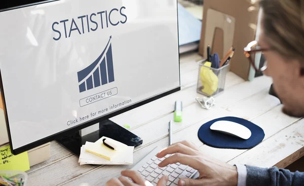 Üzletember számítógépen statisztikákkal dolgozik — Stock Fotó