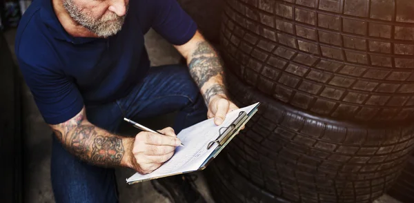 Homem mecânico escrever notas sobre carro — Fotografia de Stock
