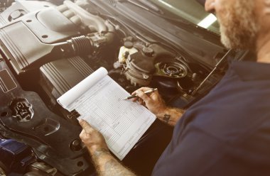 man mechanic writing notes about car clipart