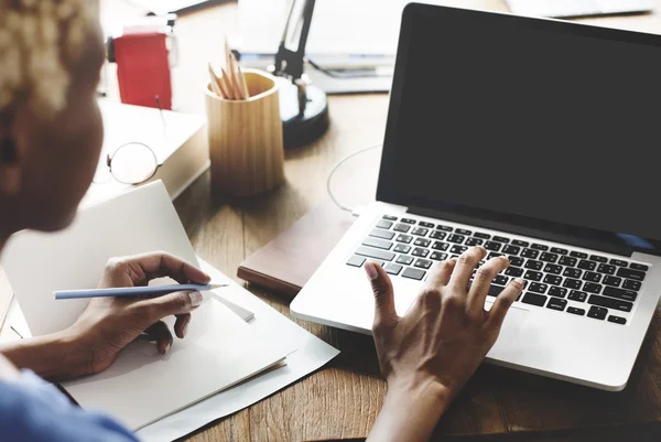 Vrouw die werkt op laptop met zwarte monitor — Stockfoto