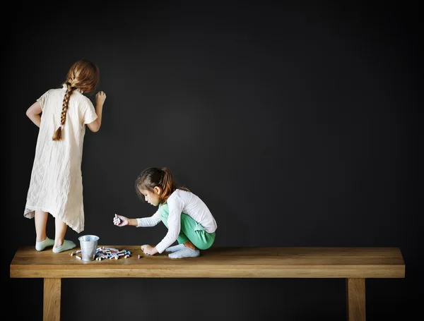 Zwei kleine Mädchen zeichnen und schreiben — Stockfoto