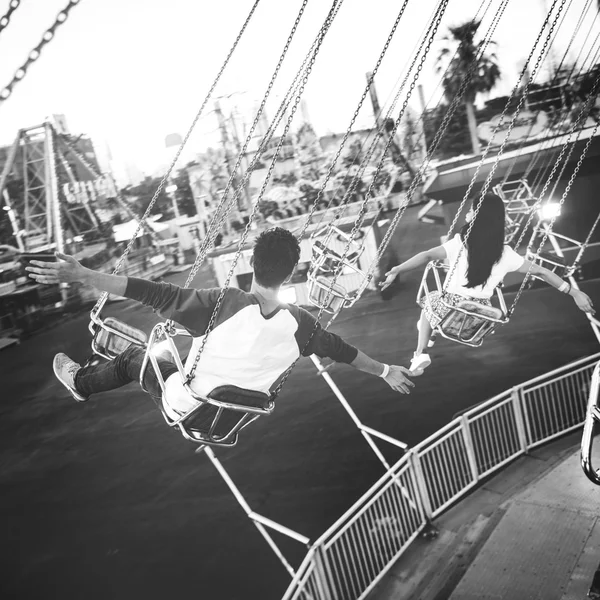 Casal balançando no parque de diversões — Fotografia de Stock