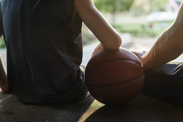 Sportman onderwijzen van jongen spelen basketbal — Stockfoto