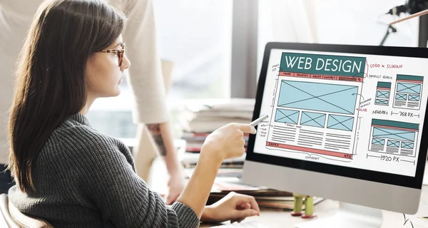 Mujer mostrando en monitor con diseño web —  Fotos de Stock