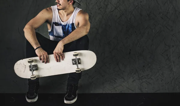 Hipster man bedrijf skateboard — Stockfoto