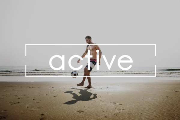 Bonito homem jogar futebol na praia — Fotografia de Stock