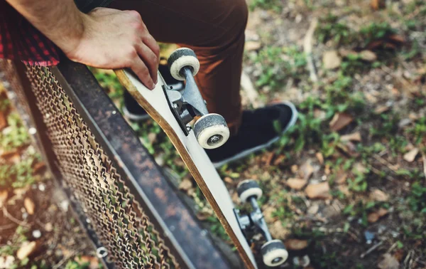 Bokovky muž hospodářství skateboard — Stock fotografie