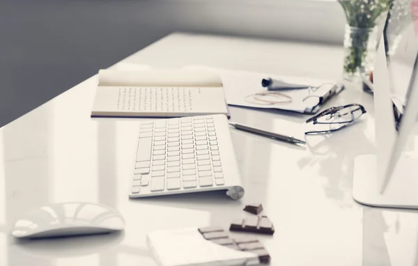 Рабочее пространство с клавиатурой, книгой и шоколадом — стоковое фото