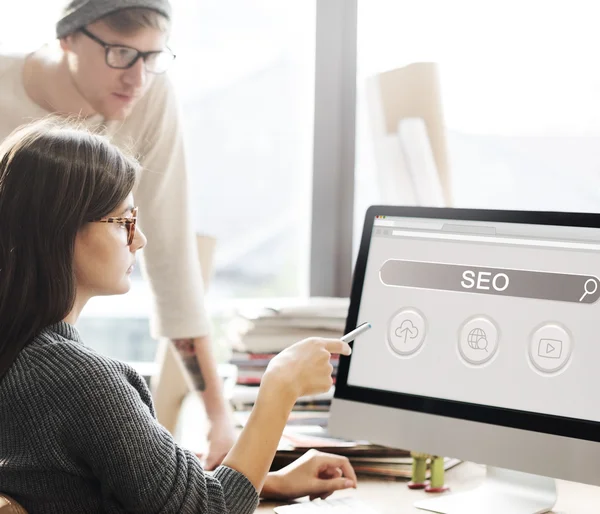 Woman showing on monitor with seo — Stock Photo, Image