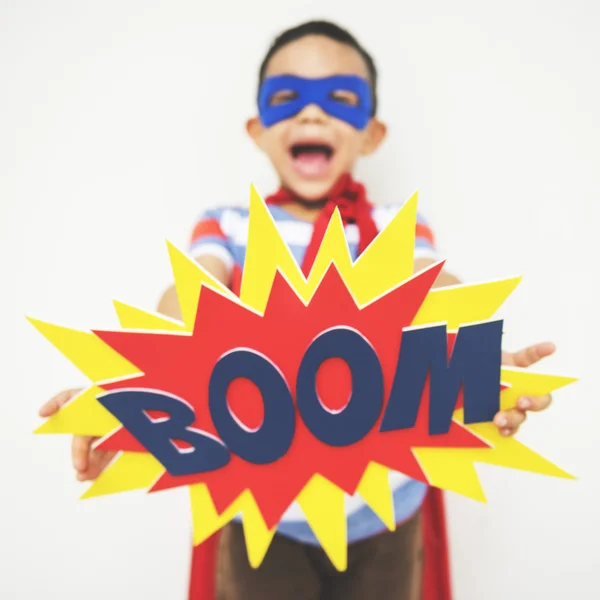 Маленький мальчик-супергерой с цветным BOOM — стоковое фото