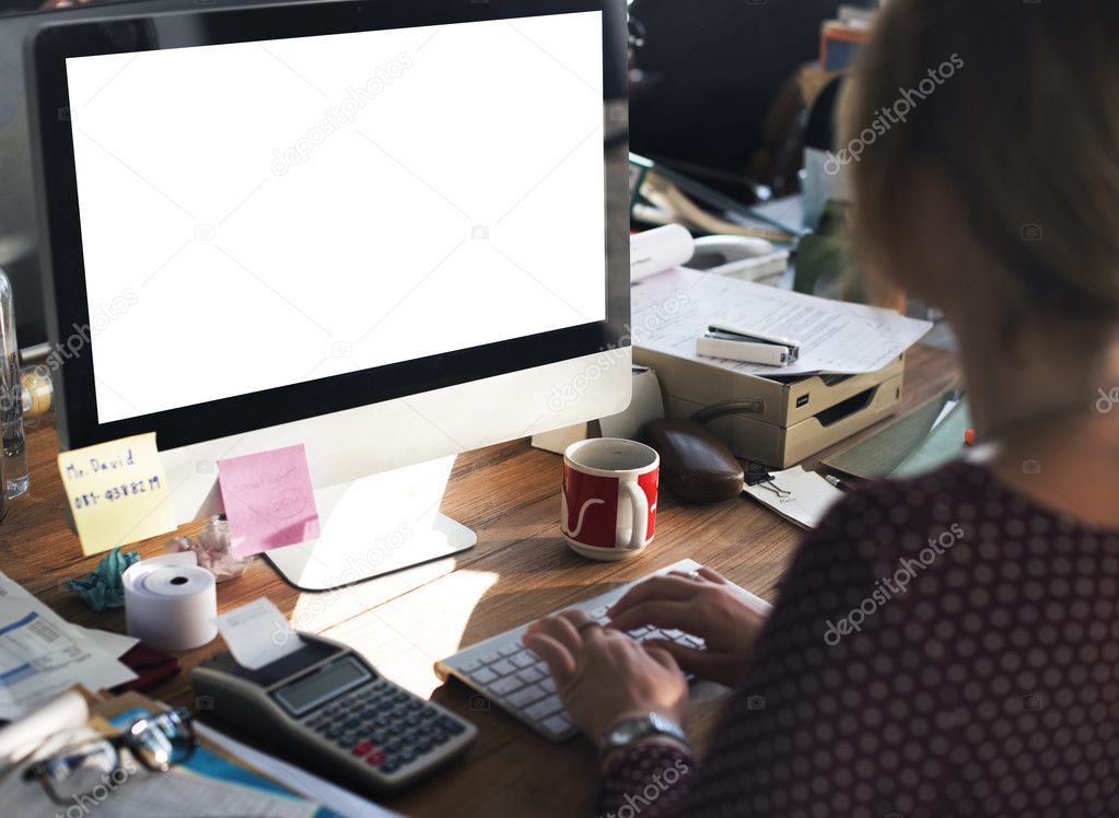 businesswoman working on computer with blank monitor 