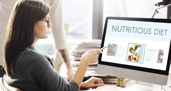 Kvinna visar på monitor med näringsrik kost — Stockfoto
