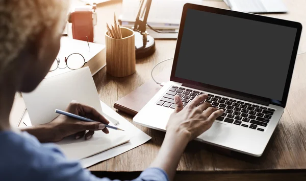 Vrouw die werkt op laptop met blok monitor — Stockfoto