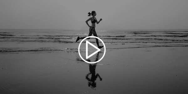 Kvinnan joggar på stranden — Stockfoto