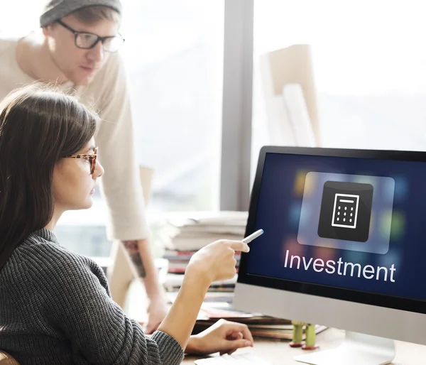 Frau zeigt mit Investition auf Monitor — Stockfoto