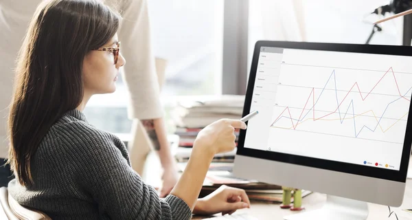 Woman showing on monitor with graph — Stock Photo, Image