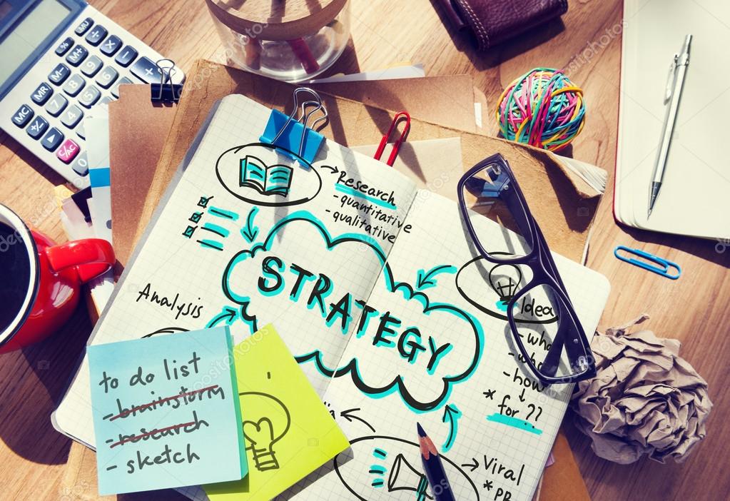 Workplace table with office tools, text in diary: Strategy