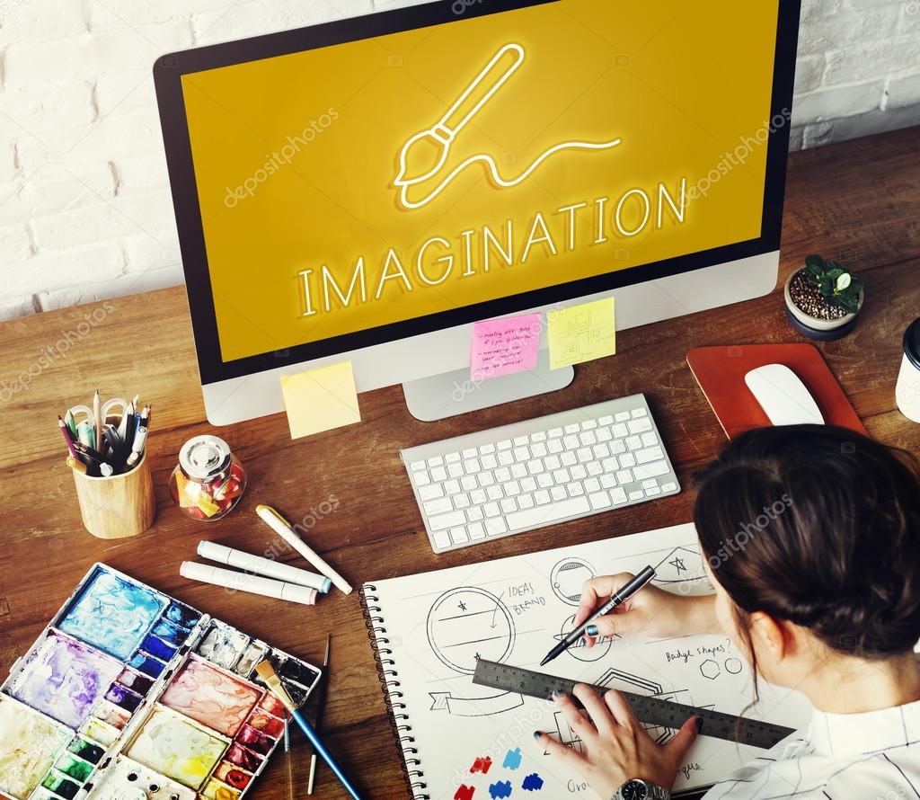 Creative woman drawing in album, computer monitor with text: Imagination