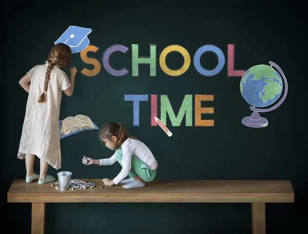 Cute sisters drawing on blackboard — Stock Photo, Image