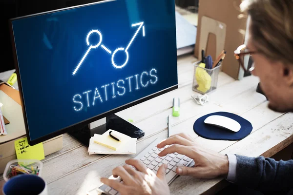 Üzletember számítógépen statisztikákkal dolgozik — Stock Fotó