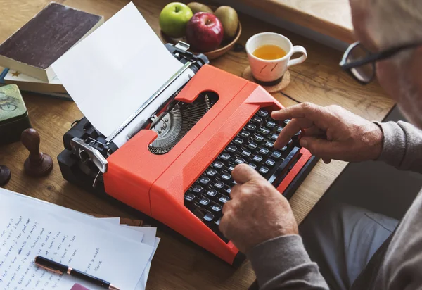 Ανώτερος άνθρωπος γράφει στη γραφομηχανή μηχανή — Φωτογραφία Αρχείου
