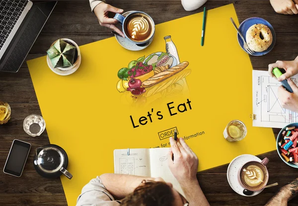 Table with poster with Let's Eat — Stock Photo, Image