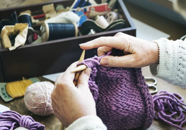 Babička pletení fialový šátek — Stock fotografie