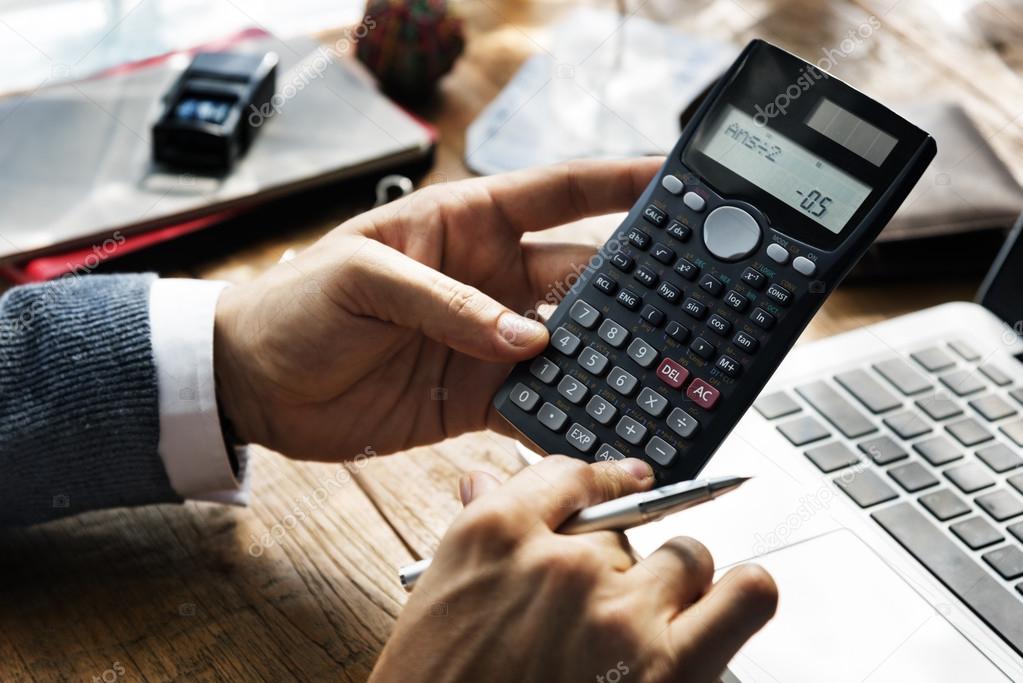 businessman counting on calculator