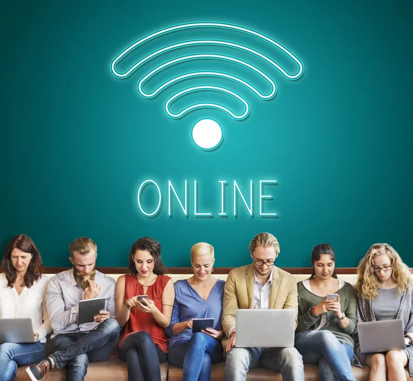 Folk sitter med enheter och online — Stockfoto