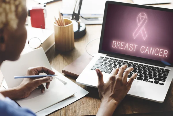 Kobieta pracuje na laptopie z rakiem piersi — Zdjęcie stockowe