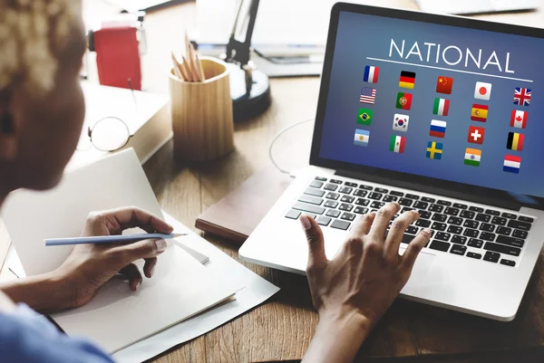 Woman working on laptop with National — Stock Photo, Image