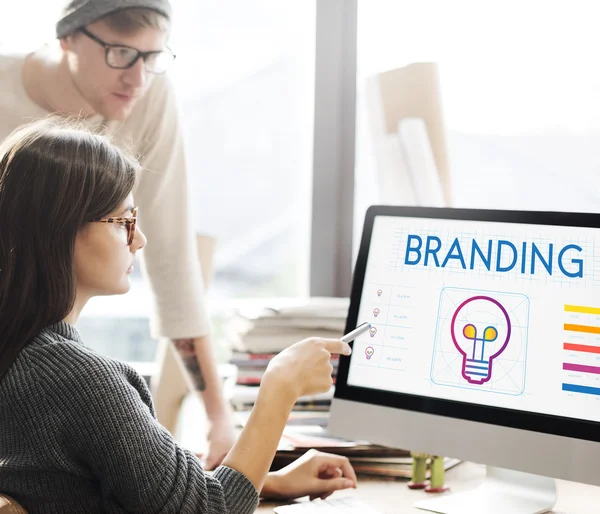 Donna che mostra sul monitor con branding — Foto Stock