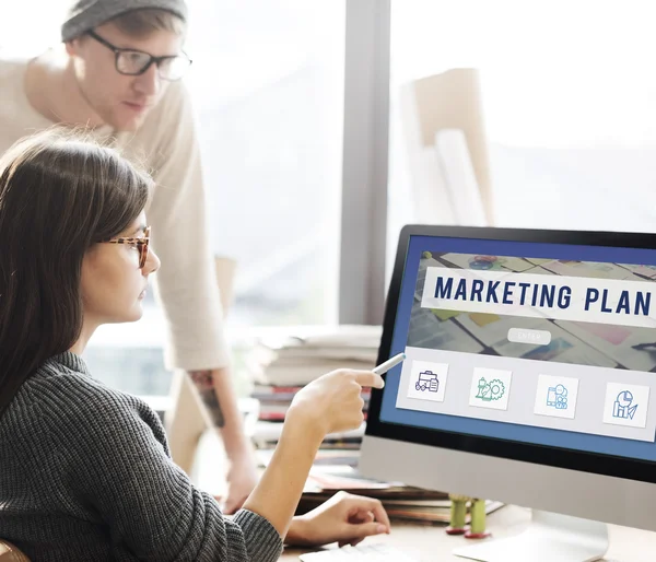 Žena ukazuje na monitoru s marketingový plán — Stock fotografie