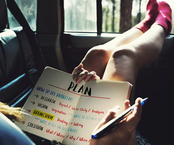 Woman lying in car, holding diary — Stock Photo, Image