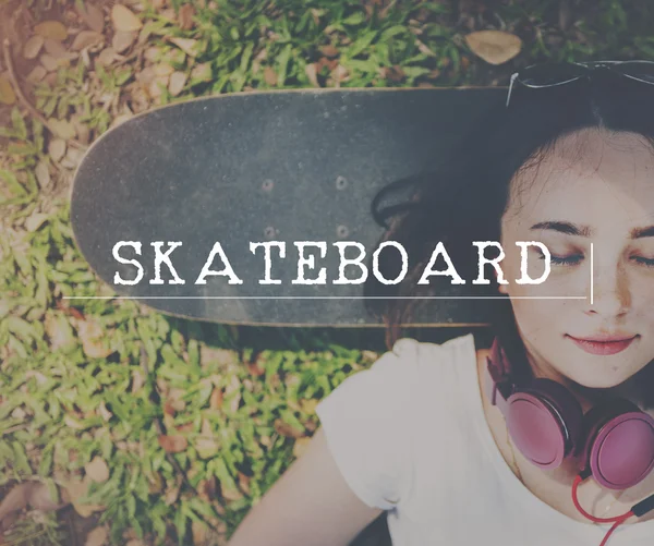 Meisje liggend op skateboard op achtergrond — Stockfoto