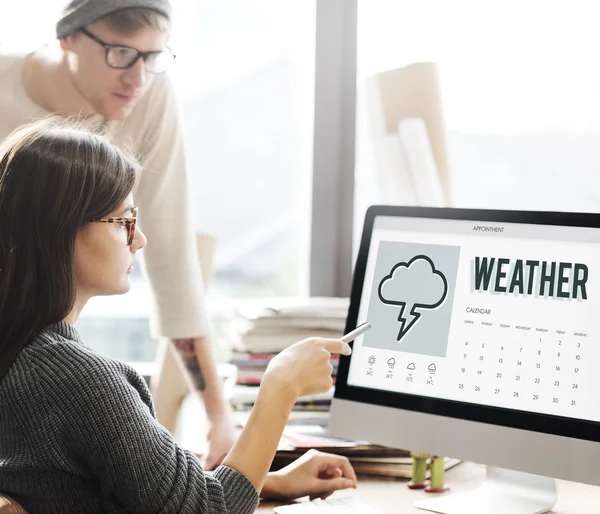 Frau zeigt bei Wetter auf Monitor — Stockfoto