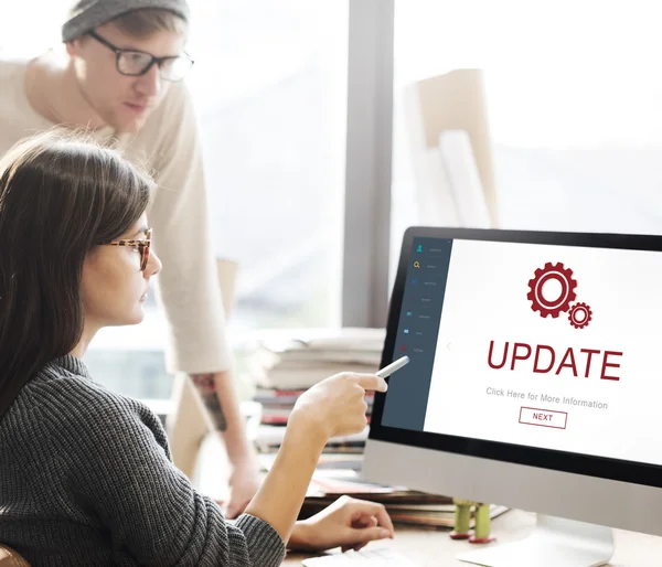 Frau zeigt auf Monitor mit Update — Stockfoto