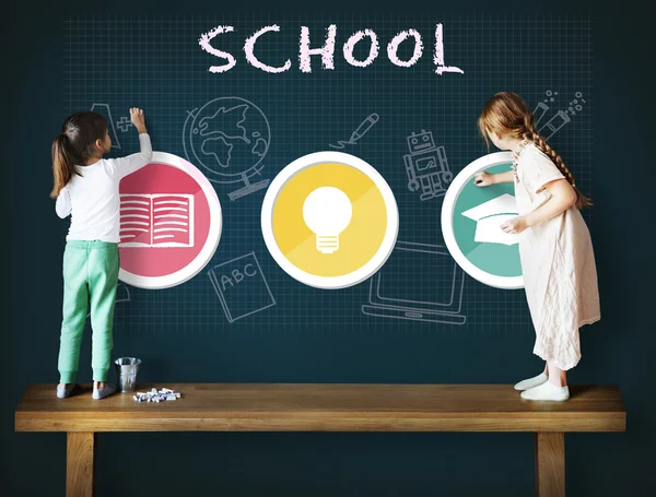 Cute sisters drawing on blackboard — Stock Photo, Image